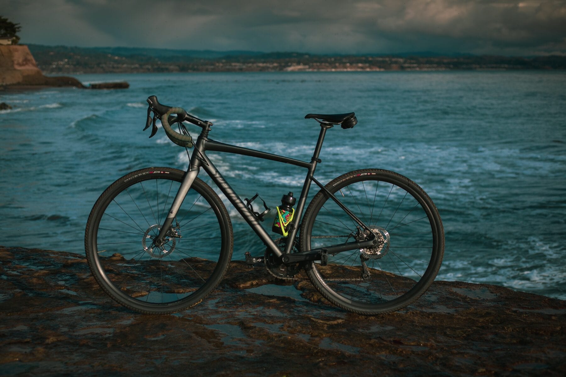 Zwarte gravelbike aan zee