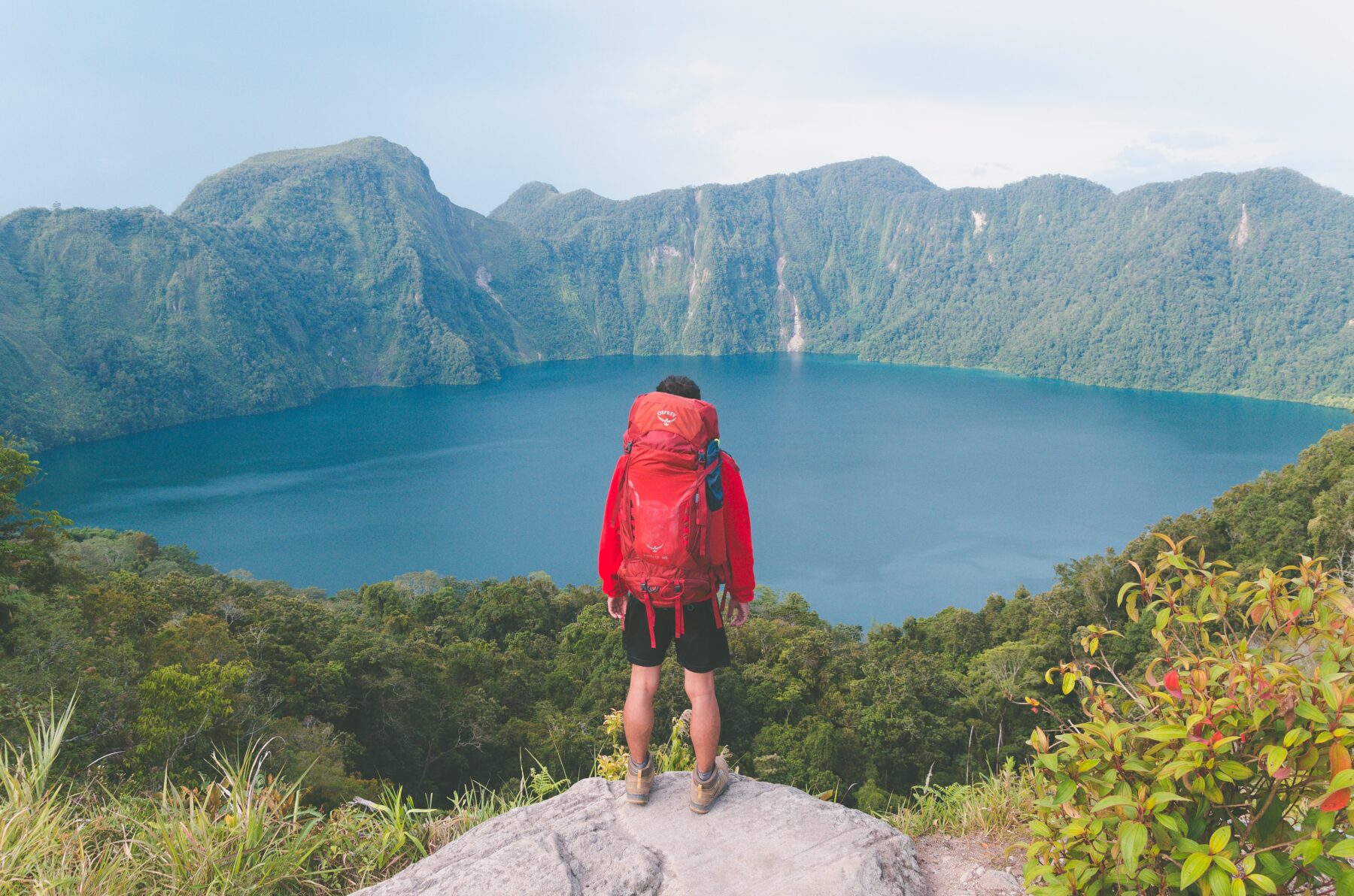 Backpacker met uitzicht over een meer en bergen