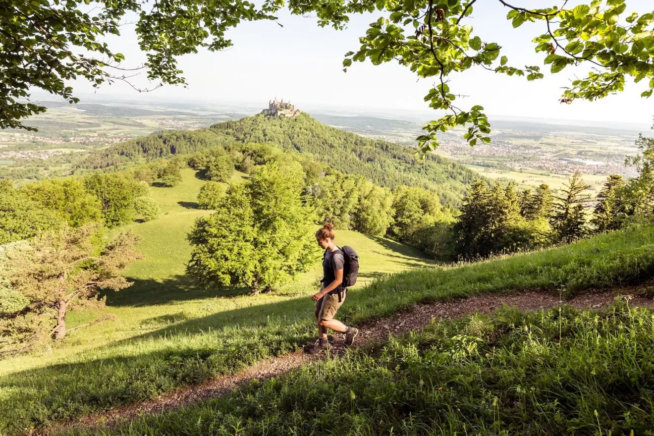 Traufgang Zollernburg-Panorama, Albstadt-Onstmettingen, Baden-Württemberg, Germany: A female hiker with the Hohenzollern Castle in the background. Meerdaagse wandelroutes Duitsland