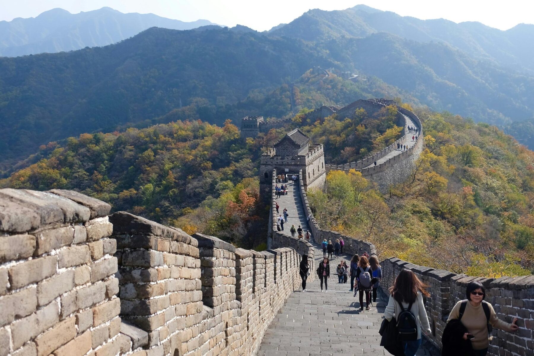 Meerdere mensen wandelend over een lange muur in China.
